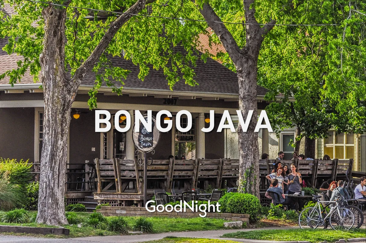 A bustling café scene with the Bongo Java sign, outdoor seating filled with people socializing and enjoying coffee, and bicycles parked nearby. The setting is casual and friendly, with a distinct local vibe.