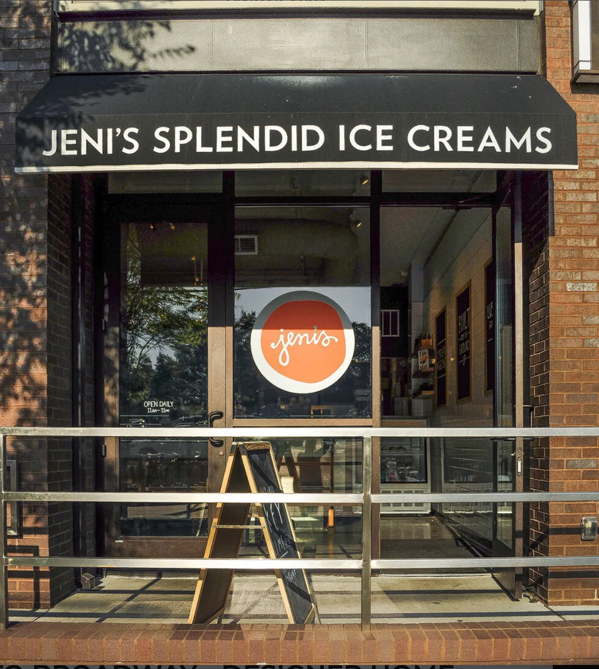 The image displays a cheerful storefront with inviting signage and a visible menu board, with people enjoying ice cream outside. The scene is lively and relaxed, ideal for families stopping for a treat during a neighborhood walk.